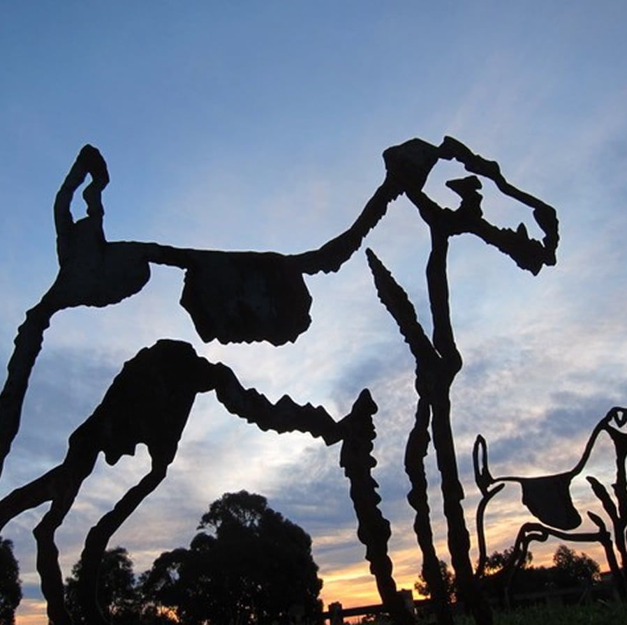 sculpture of dogs with sunst sky behind