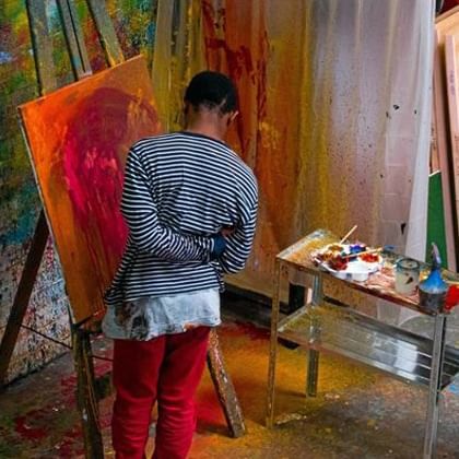 person painting at easel