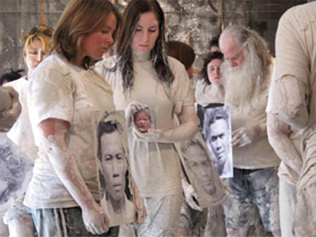 people covered in mud hold photographic portraits of people who died in volcano disaster 