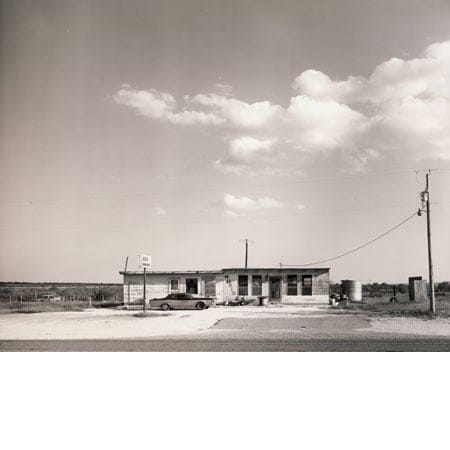 bacl and white image of Texas roadhouse with a car out the front
