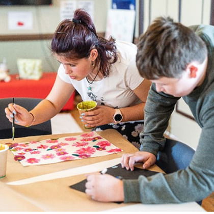 Two young people painting at a table
