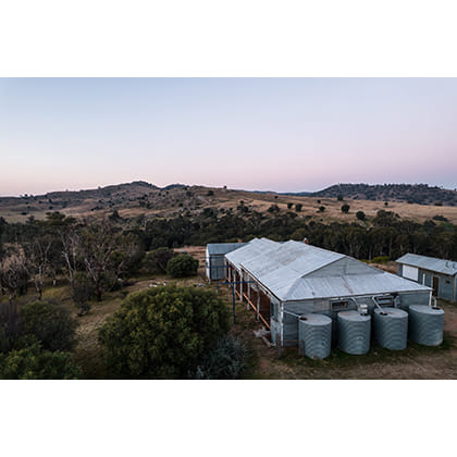 agricultural sheds surrounded by trees and rolling hills 