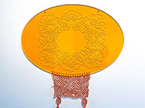 lace work hanging from disc with floral relief pattern