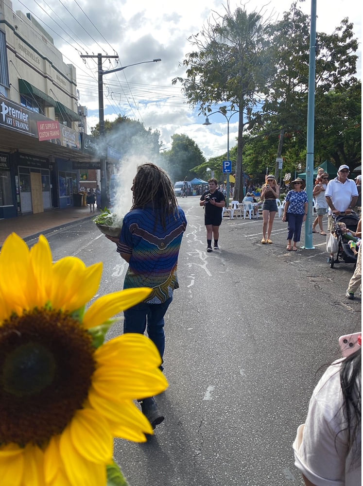 Uncle Gilbert performing smoking ceremony in town street