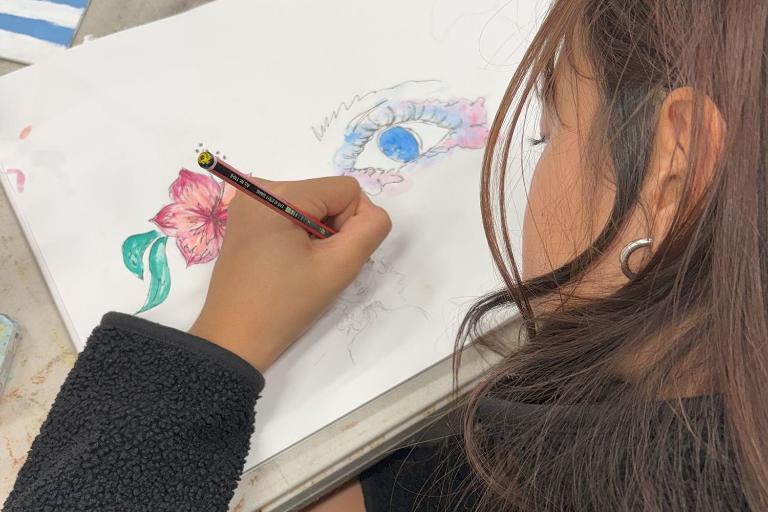 A teen making a coloured penail drawing