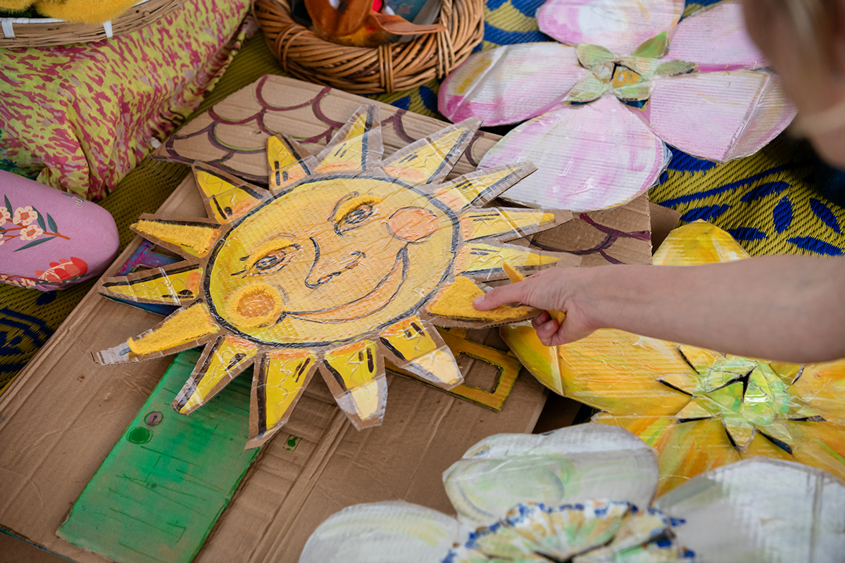 A child playing with a painted, cut out sun