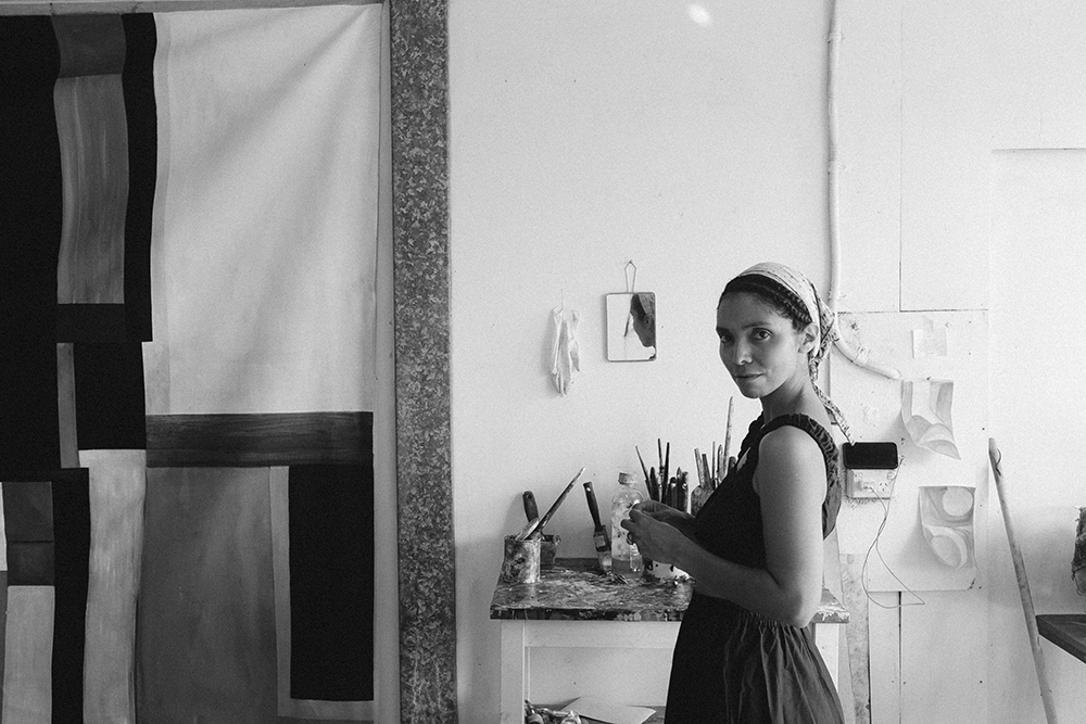 A black and white photo of the artist in the studio