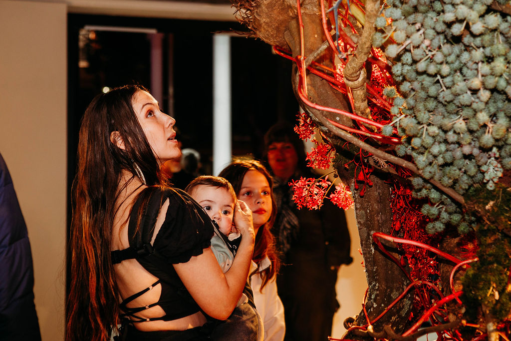 A woman and children looking at a large sculpture