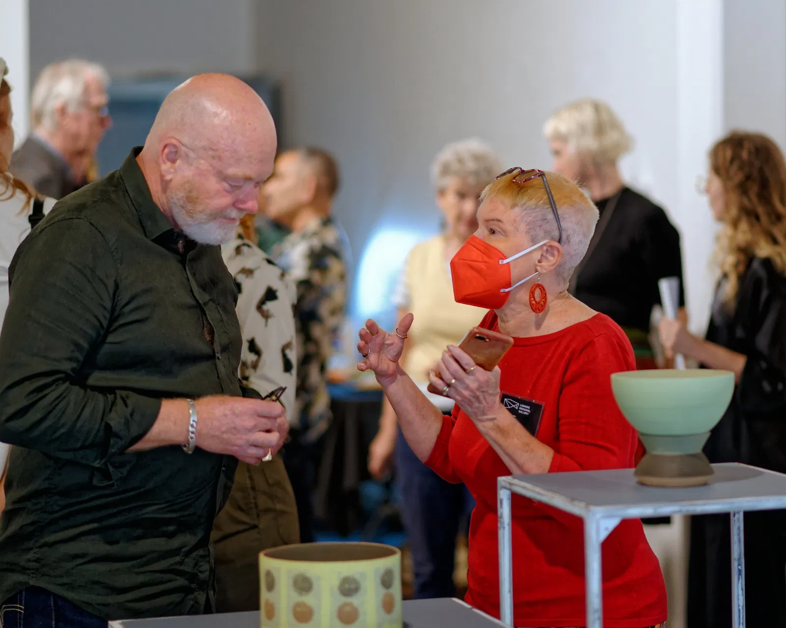 Two people having a conversation at an exhibition opening