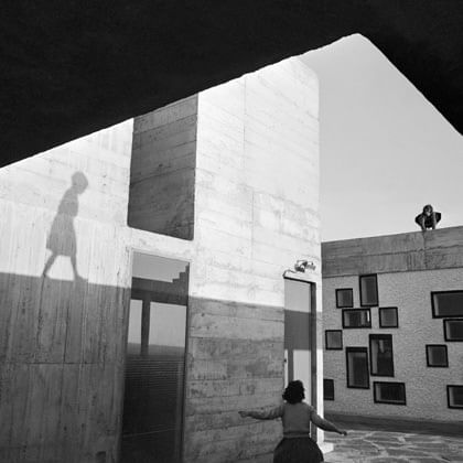 buildings with shadow of a child  and woman walking in the  foreground