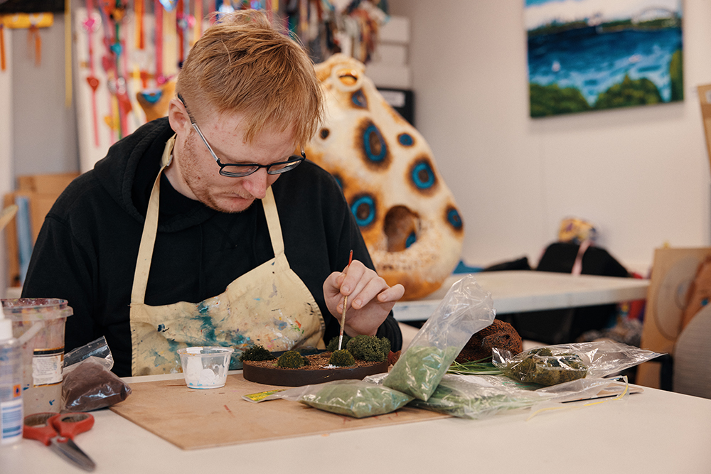 A man in an artist studio painting 