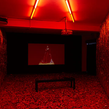 room with red lighting and red walls and floor with a large screen