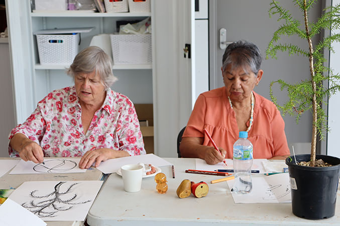 two women making artwork