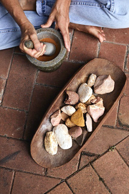 person grinding rocks to make ochre