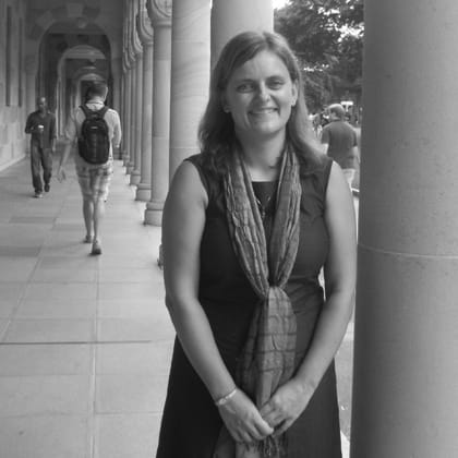 Andrea Bubeniek standing next to column in a covered colonnade walkway