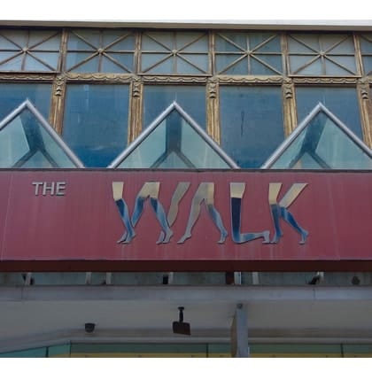 Building facade with with banner with image of walking legs across the front 