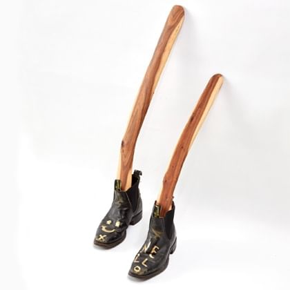 pair of RM WIlliams boots with two boomerangs in them against a wall