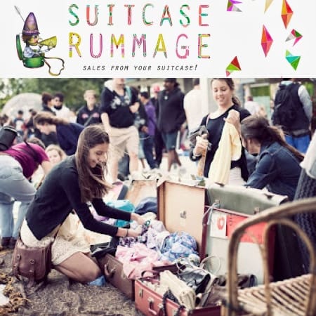 crowd of people at rummage sale with woman in the foreground crouched down looking through clothes in a suitcase 