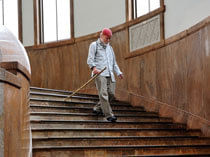Akio Suzuki carrying long flute walking down curved staircase