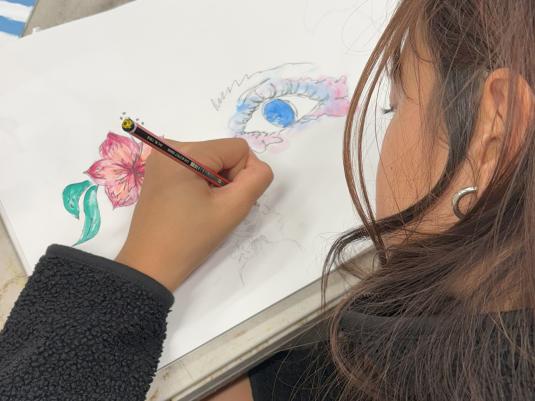 A teen making a coloured penail drawing