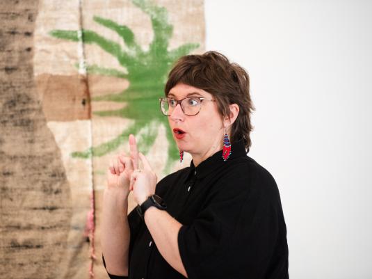 Sigrid Macdonald signing, in front of artworks by Mark Maurangi Carrol. Photo by Elise Derwin
