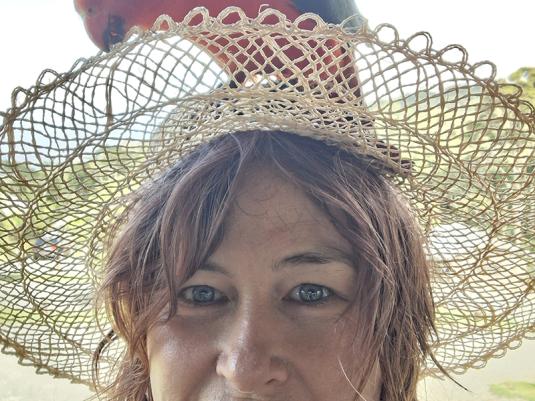 A portrait of a woman wearing a hat with a parrot on her head