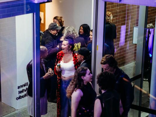 A group of people chatting during an exhibition opening