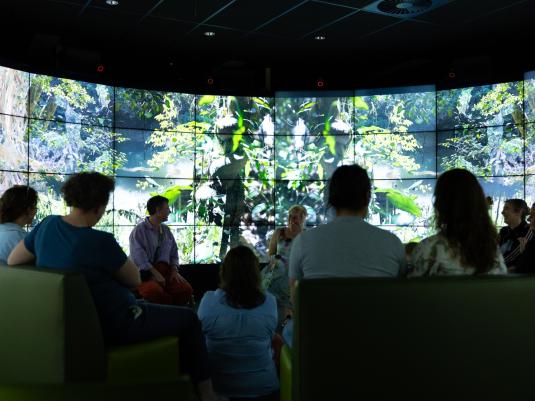 A room of people looking at a large projection