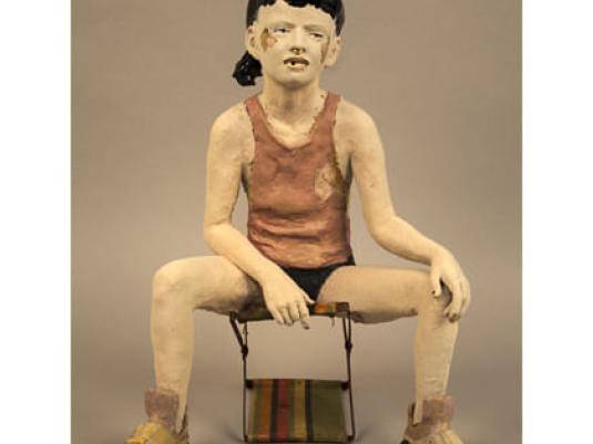 sculpture of a young person sitting on a stool