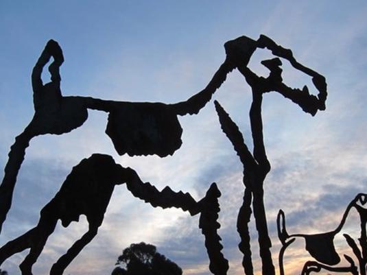 sculpture of dogs with sunst sky behind