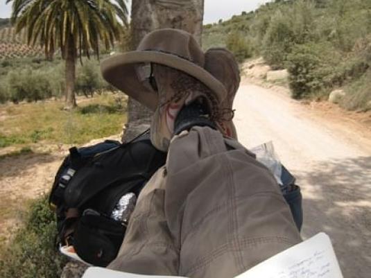 person resting on the trail with feet up on back packs