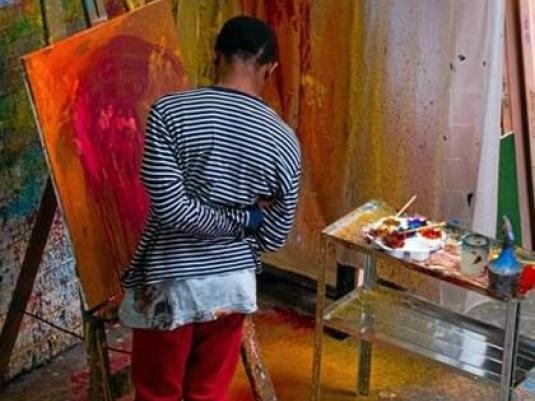 person painting at easel