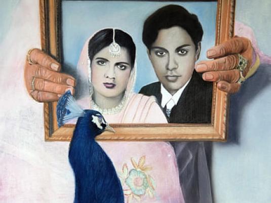 framed image of man and woman with a peacock in front