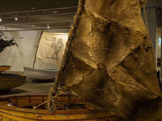 boat with animal skin sails in foreground with another boat behind
