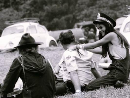 protesters sitting with policman, giving him a massage