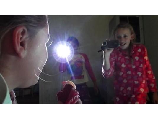 One child videoing two others