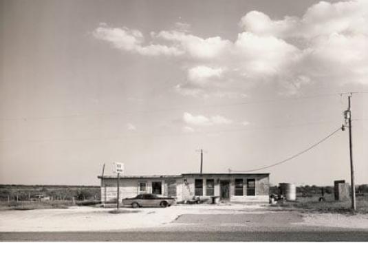 bacl and white image of Texas roadhouse with a car out the front
