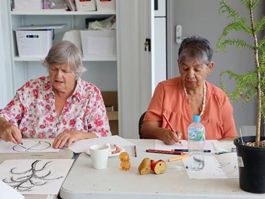 two women making artwork