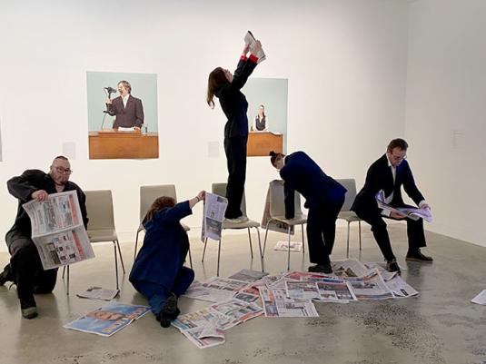 people reading  surrounded by newspapers