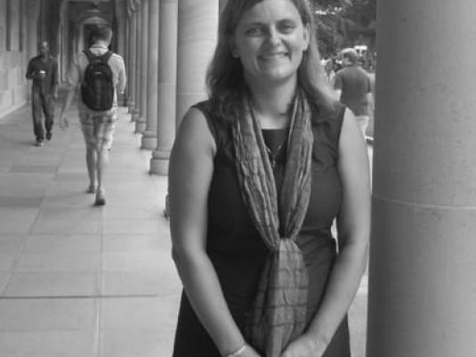 Andrea Bubeniek standing next to column in a covered colonnade walkway