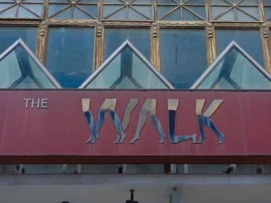 Building facade with with banner with image of walking legs across the front
