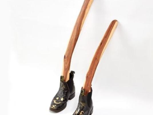 pair of RM WIlliams boots with two boomerangs in them against a wall