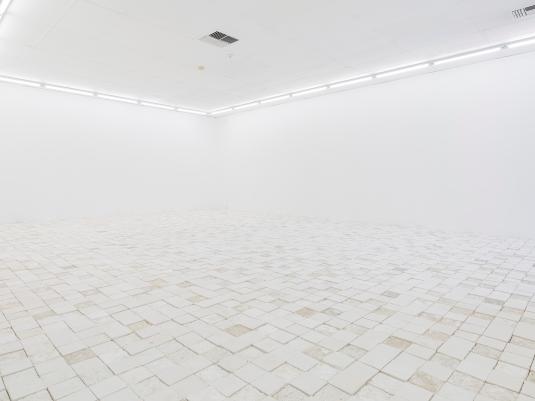 A photo of a gallery with many chalk tiles like pavement on the floor.