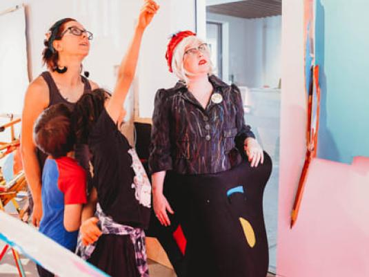 Peggy Popart with two chidren and another woman looking at something up high that is out of the photo shot