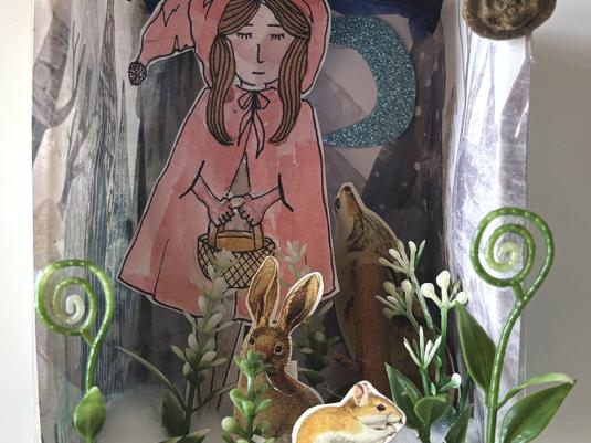 A 3D diorama depicting a forest scene, with a young girl carrying a basket, a squirrel, fox, rabbit, plants and a glittering cresent moon